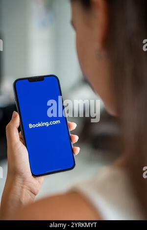 Prag, Tschechische republik - 2. Mai 2024: Frau mit iPhone mit Logo der Anwendung Booking.com auf dem Bildschirm, mit mobiler Anwendung Stockfoto