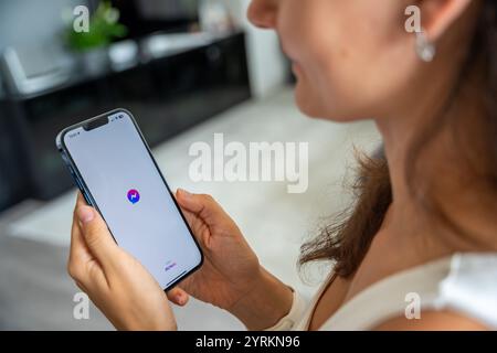 Prag, Tschechische republik - 2. Mai 2024: Frau mit iPhone mit Logo der Anwendung Messenger von Meta Facebook auf dem Bildschirm, mit mobiler Anwendung Stockfoto