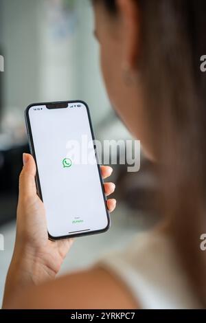 Prag, Tschechische republik - 2. Mai 2024: Frau hält iPhone mit Chat-Anwendung WhatsApp auf dem Bildschirm, die mobile Anwendung für das Business Home verwendet Stockfoto