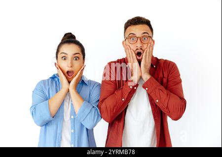 Schockierte Männer und Frauen arabischer oder kaukasischer Herkunft, beide halten ihre Hände ungläubig an ihre Gesichter, drücken Überraschung und Verwunderung aus, lässige Kleidung, stehen auf isoliertem weißen Hintergrund Stockfoto