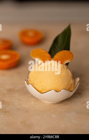 Eine Kugel Mandarineneis in einem Milchkännchen Stockfoto