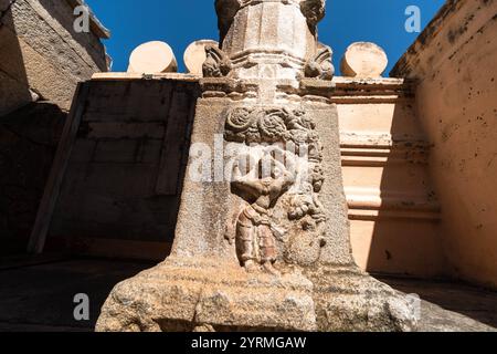 Geschnitzte Figuren an den Wänden von Shravanabelagola, unter einem klaren blauen Himmel. Stockfoto