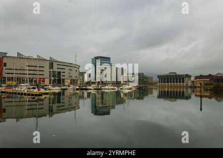 Belfast County Antrim N. Ireland 08. November 2024 - Belfast Skyline vom Titanic Walkway mit Yachten im Yachthafen und Reflexionen im Wasser Stockfoto