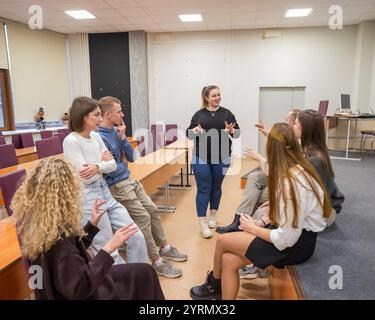 Junge Menschen kommunizieren in Gebärdensprache in einem Universitätsklassenzimmer. Stockfoto