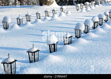 Kleine Laternen auf finnischen Kriegsgräbern im Winter Stockfoto