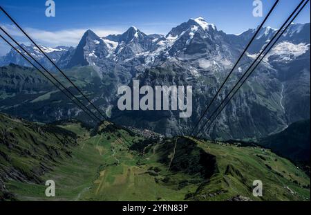 Blick von der Seilbahnstation Birg über Almwiesen, das Alpendorf Mürren, Eiger, Mönch und Jungfrau, Berner Oberland, Schweiz Stockfoto