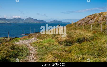 Der Hag of Beara, ein Felsen in Kilcatherine, Beara Peninsula, stellt eine alte irische Gottheit dar, mit Kenmare Bay und den Slieve Miskish Mountains Stockfoto