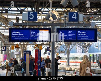 Köln, Deutschland - 9. Juni 2024: Zuginformationsschilder über einem stark frequentierten Bahnsteig am Bahnhof Köln - Köln - Hauptbahnhof. Stockfoto
