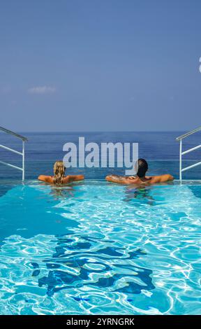 Frau und Mann entspannen am Rand des Infinity-Pools auf dem Achterdeck des Expeditionskreuzfahrtschiffs SH Diana (Swan Hellenic), auf See, in der Nähe von Saudi Ara Stockfoto