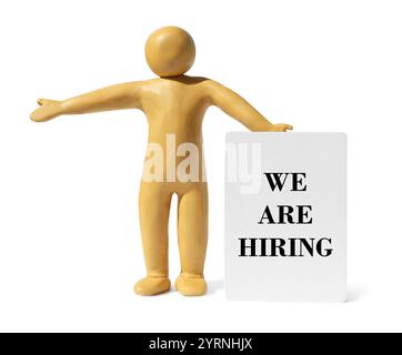 Plastilin-menschliche Figur, die ein Schild mit dem Text We are Hiring hält, isoliert auf weiß Stockfoto