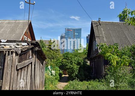 Alte Holzhäuser umgeben von modernen Bürotürmen im Stadtteil Snipiskes, Vilnius, Litauen, Europa Stockfoto