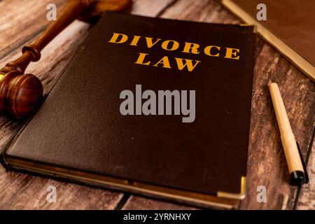 Scheidungsbuch, Hammer und Stift auf einem Holztisch. Recht-, Trennungs- und familienrechtliches Konzept. Stockfoto