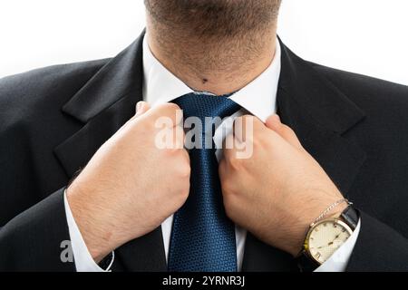 Nahaufnahme eines erwachsenen Geschäftsmannes, der einen weißen Hemdkragen mit Anzug und blauer Krawatte arrangierte, der sich für die moderne Büroarbeit des Unternehmens auf weiß vorbereitete Stockfoto