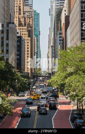 New York, NY, USA-11. November 2024: Verkehr auf der belebten Stadtstraße, umgeben von Wolkenkratzern. Stockfoto