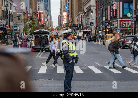 New York, New York, USA-11. November 2024: Verkehrspolizist lenkt den Verkehr auf der geschäftigen Midtown Manhattan Street. Stockfoto