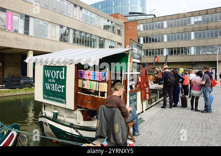 LONDON, ENGLAND, Großbritannien - 5. MAI 2014: Die Leute wählen Bücher zum Kauf in der „Word on the Water“-Bookbarge, einem Buchladen auf der Barge, die den Regents Canal hinauf und hinunter fährt Stockfoto