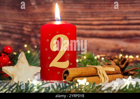 4. Dezember 2024: Die zweite Adventskerze brennt für den zweiten Adventstag. Eine rote Kerze mit der Nummer 2 vor der Weihnachtsdekoration. PHOTOMONTAGE *** zweite Adventskerze zum zweiten Adventbrennt. Eine rote Kerze mit der Zahl 2 vor weihnachtlicher Dekoration. FOTOMONTAGE Stockfoto