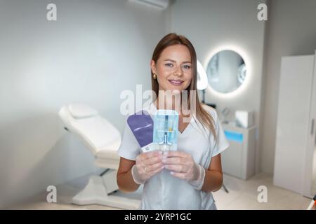 Schöne Arzt Kosmetikerin glückliche Frau hält und macht eine Wahl der Füllstoffinjektion in der medizinischen Schönheitsklinik Stockfoto