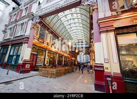 Leadenhall Market Leadenhall Market ist ein überdachter Markt in der City of London, der seit 1972 als Grade-II*-Bauwerk unter Denkmalschutz steht. Bereits im 14. Jahrhundert trafen sich rund um das Leadenhall Herrenhaus Geflügel- und Käsehändler. 1463 bekam er das Waagenrecht für Wolle, 1488 das Monopol für den Handel mit Leder. Durch den großen Brand von London 1666 wurden auch große Teile des Marktes zerstört. Das anschließend errichtete langjährige Provisorium wurde 1881 von Sir Horace Jones umgebaut, der auch den Billingsgate Market und den Smithfield Market entworfen hat. Eine Überdachu Stockfoto