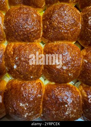 Frisch gebackene Brötchen, goldfarben und flauschig, perfekt für jede Mahlzeit, bringen Wärme und Komfort auf den Esstisch. Stockfoto