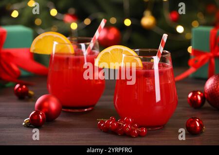 Weihnachtscocktail in Gläsern mit Zitrone und Johannisbeeren auf Holztisch Stockfoto