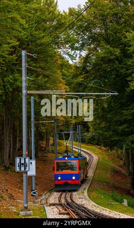 Bergbahn auf Eisenbahngleisen im Herbstwald in Monte Generoso, Tessin, Schweiz. Stockfoto