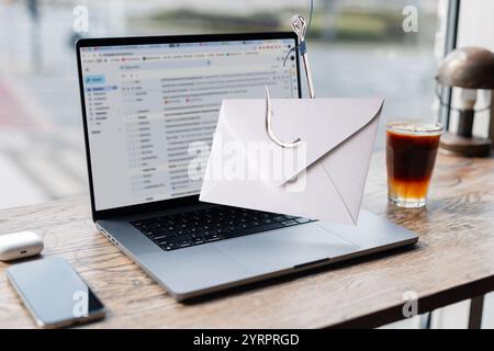 Benachrichtigungsnachricht Spam auf Hook, Virenkonzept. Die Post kam vom Display zum Laptop. Phishing, kreative Idee. Diebstahl persönlicher Daten. Postversand und Marketin Stockfoto