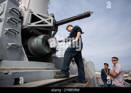 Von links: USS Comstock (LSD 45) Fire Controlman Petty Officer 2nd Class Ferrie Maxwell rotiert die vulkanischen Fässer des Achterbahn Phalanx Close-in Weapon System (CIWS) unter den wachsamen Augen von Dan Le, einem Mitarbeiter des Combat Systems Assessment Team (CSAT) Operations Support Support Mitarbeiter des Naval Surface Warfare Center (NSWC) Port Hueneme Division (NSWC), und Alex Bridgnell, CIWS in der NS3. Juni 2024 in Kalifornien. Das CIWS feuert 20-mm-Schüsse mit einer Geschwindigkeit von bis zu 3.000 pro Minute ab. (US Navy Foto von Eric Parsons/Rele Stockfoto