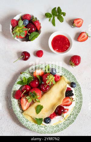 CR pes mit Erdbeercoulis, Schlagsahne und frischen Beeren Stockfoto