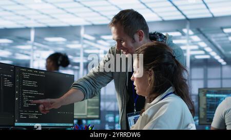 Frau, die Hilfe von leitenden Ingenieuren anfordert, um Fehler im High-Tech-KI-Rechenzentrum zu beheben. Mitarbeiter, der Hilfe von IT-Experten benötigt, um Supercomputer mit künstlicher Intelligenz zu reparieren, Kamera A Stockfoto