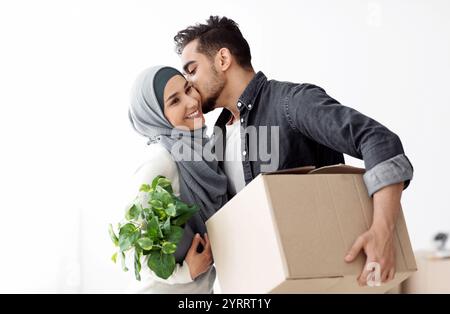 Gutaussehender Kerl, der seine glückliche Frau küsst und zusammen zieht Stockfoto