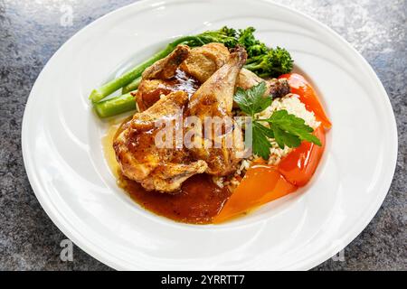 Ein Teller mit Hühnchen, Brokkoli und Reis. Das Huhn ist gekocht und hat Soße drauf. Der Brokkoli ist grün und der Reis weiß. Die Platte ist Stockfoto