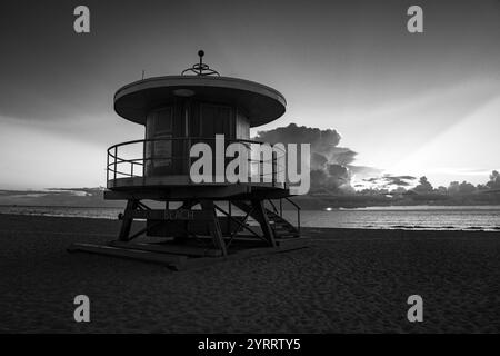 APRIL 2022, SOUTH MIAMI BEACH, FL., USA - Sonnenaufgang am Miami Beach mit Rettungsschwimmerstand in Silhouette Stockfoto