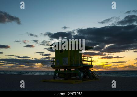 APRIL 2022, SOUTH MIAMI BEACH, FL., USA - Sonnenaufgang am Miami Beach mit Rettungsschwimmerstand in Silhouette Stockfoto