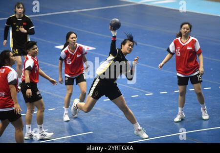 Neu-Delhi, Indien. Dezember 2024. Jiang Xingtong (2. R) aus China wirft den Ball während des Gruppenspiels gegen Singapur bei der 20. Asiatischen Handball-Meisterschaft der Frauen in Neu-Delhi, Indien, 4. Dezember 2024. Quelle: Str/Xinhua/Alamy Live News Stockfoto