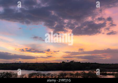 Rosa und Orange dramatischer und farbenfroher Himmel über einem Grashorizont. Das Foto wurde vom Sonnenuntergang in San Antonio Texas während der goldenen Stunde gemacht Stockfoto