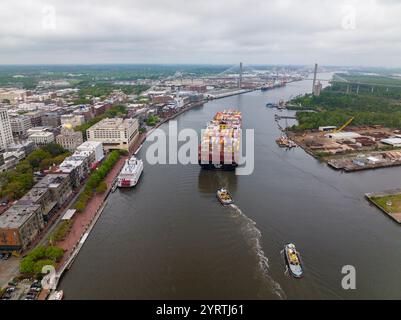 6. APRIL 2022, SAVANNAH GEORGIA, USA – aus der Vogelperspektive der historischen Stadt Savannah Georgia und des Savannah River sind zwei Schlepper und ein Seefrachtschiff mit Containern zu sehen Stockfoto