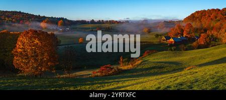 10/22 WOODSTOCK VERMONT – USA – Herbstsonnenaufgang mit Nebel über der klassischen Jenny Farm zeigt Herbstfarben, südlich von Woodstock, VT Stockfoto