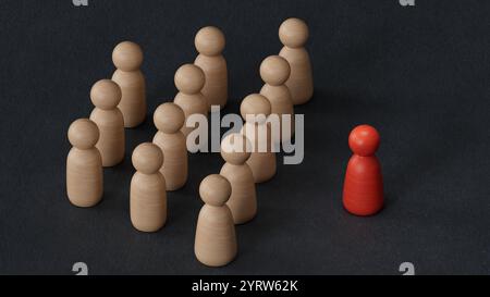 Eine Holzfigur, die mit einem Team steht, um Einfluss zu nehmen und zu ermächtigung. Konzept der Führung, erfolgreicher Wettbewerbssieger und Leader mit Einfluss und Stockfoto