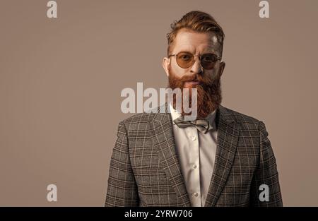Tuxedo bärtiger Mann in eleganter formeller Herrenbekleidung mit Anzugsjacke und Schleife isoliert auf Grau, Kopierraum Stockfoto