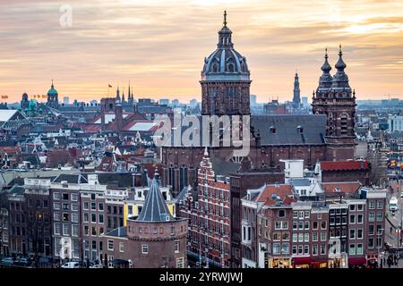 Gebäude der Skyline von Amsterdam während eines dramatischen goldenen Sonnenuntergangs. Foto am Abend in Amsterdam Niederlande Stockfoto