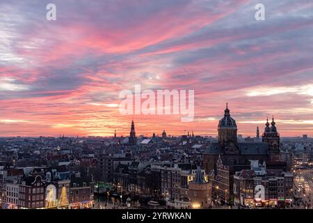 Gebäude der Skyline von Amsterdam während eines dramatischen rosa Sonnenuntergangs. Foto am Abend in Amsterdam Niederlande Stockfoto