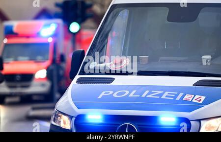 Berlin, Deutschland. Dezember 2024. Ein Polizeiauto und ein Krankenwagen mit blinkenden blauen Lichtern. Quelle: Jens Kalaene/dpa/Alamy Live News Stockfoto