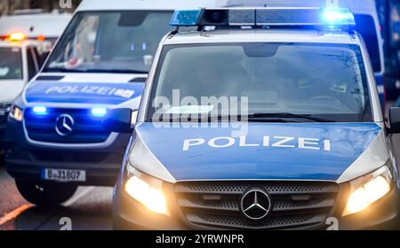 Berlin, Deutschland. Dezember 2024. Polizeiautos mit Scheinwerfern an und blinkenden blauen Lichtern. Quelle: Jens Kalaene/dpa/Alamy Live News Stockfoto