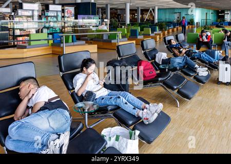 Passagiere, die Liegestühle im Terminalgebäude des internationalen Flughafens Schipol, Amsterdam, Holland, nutzen Stockfoto