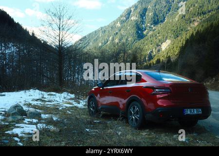 Camlihemsin, Rize, Turkiye - 15. November 2024 : Ein roter Citroen C4X fährt auf einer schneebedeckten Bergstraße Stockfoto