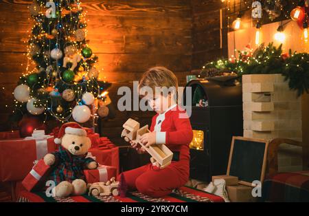 Kindheitserinnerungen. Santa Boy, kleines Kind, feiert weihnachten. Junge Kind spielt in der Nähe des weihnachtsbaums. Neujahrszähler. Frohe und helle weihnachten Stockfoto