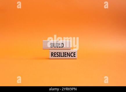 Symbol für Belastbarkeit erstellen. Holzklötze mit Wörtern sorgen für Widerstandsfähigkeit. Wunderschöner orangefarbener Hintergrund. Business- und Build Resilience-Konzept. Kopierbereich. Stockfoto