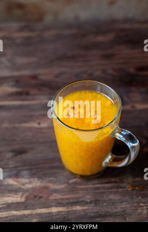 Sanddorntee mit Orange, Zimt und Rosmarin in Gläsern auf Holztisch. Leg den Tee auf den Tisch Stockfoto