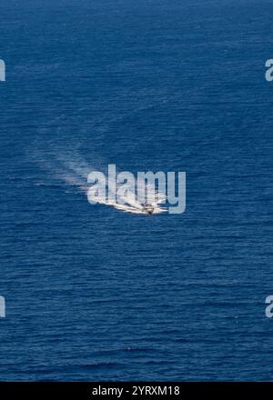 Ein kleines Vergnügen-Motorboot segelt mit hoher Geschwindigkeit auf einem ruhigen blauen Meer Stockfoto